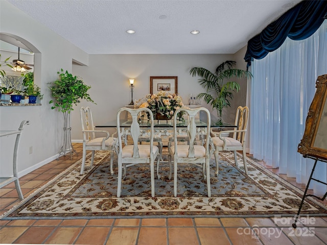 unfurnished dining area with baseboards, tile patterned flooring, recessed lighting, and a textured ceiling