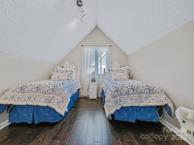 bedroom with baseboards, lofted ceiling, hardwood / wood-style flooring, and a textured ceiling