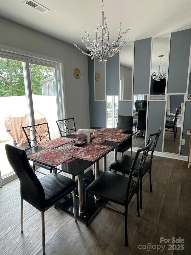 dining area featuring hardwood / wood-style flooring, plenty of natural light, and a chandelier