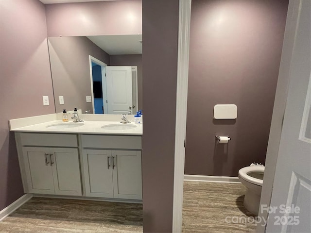 bathroom with vanity, toilet, and wood-type flooring