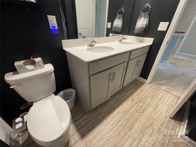 bathroom featuring vanity, wood-type flooring, and toilet