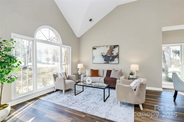 living room with high vaulted ceiling, plenty of natural light, and dark hardwood / wood-style floors