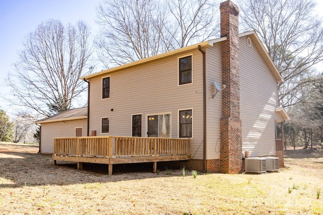 rear view of house featuring a wooden deck, central AC unit, and a chimney