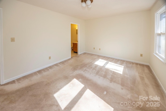 unfurnished room with light colored carpet and baseboards