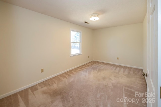 spare room featuring visible vents, baseboards, and light colored carpet