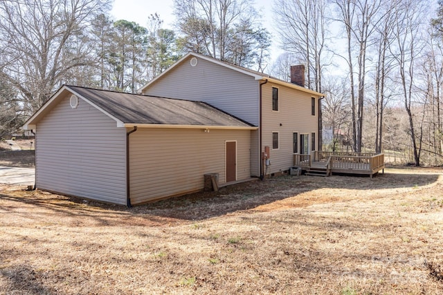 exterior space featuring a wooden deck and a chimney