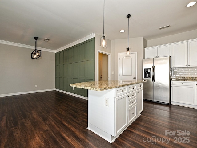 kitchen with hanging light fixtures, a center island, light stone countertops, stainless steel refrigerator with ice dispenser, and white cabinets