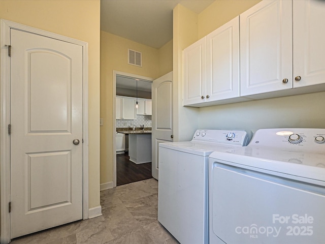 washroom featuring washing machine and dryer and cabinets