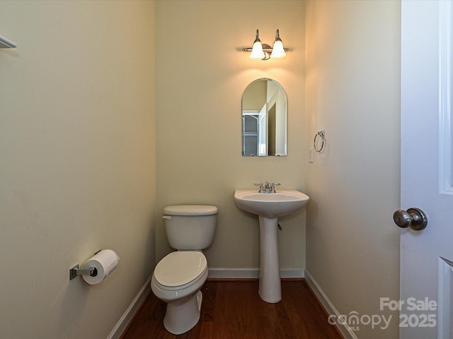 bathroom featuring toilet, sink, and hardwood / wood-style floors