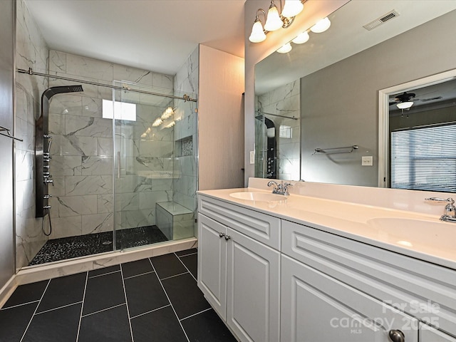 bathroom featuring a shower with door, vanity, tile patterned floors, and ceiling fan