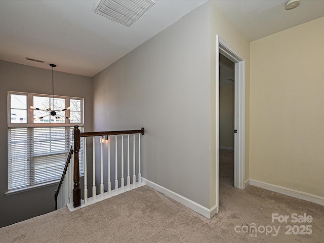 stairs featuring an inviting chandelier and carpet flooring