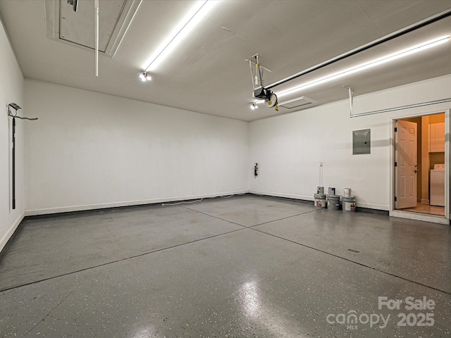 garage with electric panel, a garage door opener, and washer / dryer