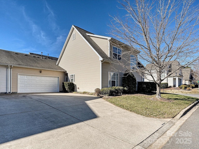 view of side of property featuring a yard and a garage