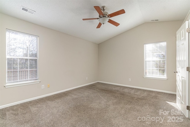 carpeted spare room with lofted ceiling, ceiling fan, and a textured ceiling