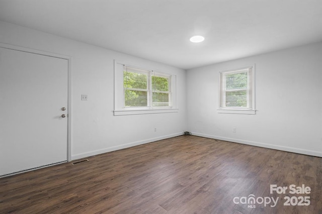 empty room with dark hardwood / wood-style flooring