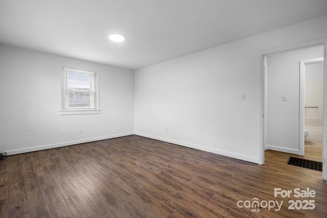 unfurnished room featuring dark wood-type flooring