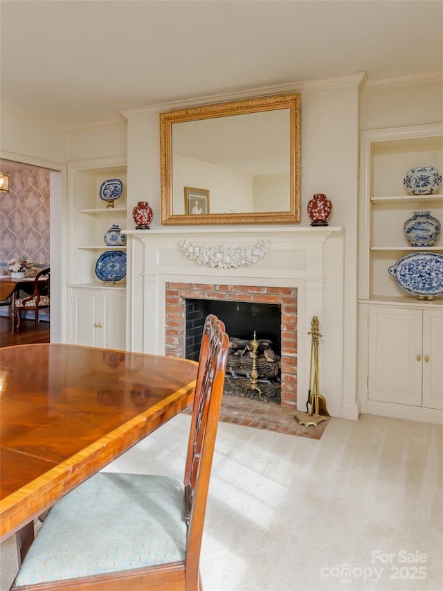 carpeted dining room featuring a brick fireplace, ornamental molding, and built in features