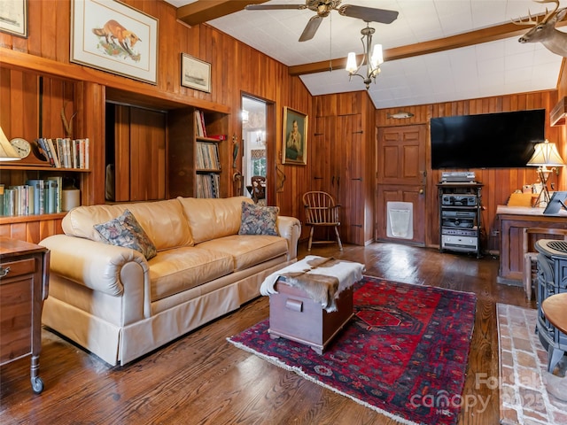 living room with dark wood-type flooring, wooden walls, vaulted ceiling with beams, and ceiling fan with notable chandelier