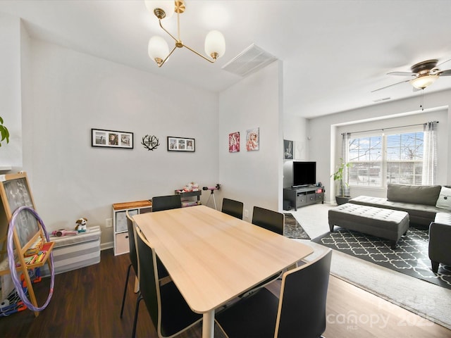 dining room featuring dark wood-type flooring and ceiling fan with notable chandelier