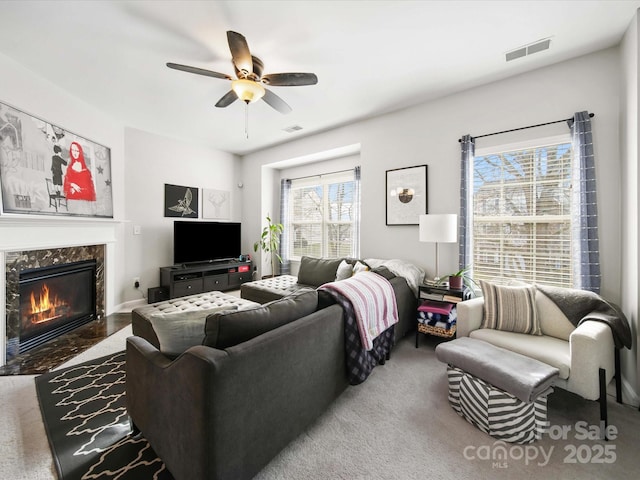 living room with ceiling fan, carpet, and a high end fireplace