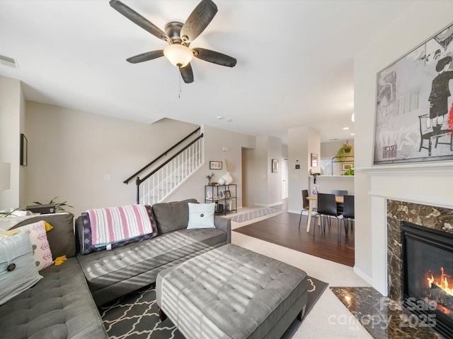 living room with ceiling fan and a fireplace