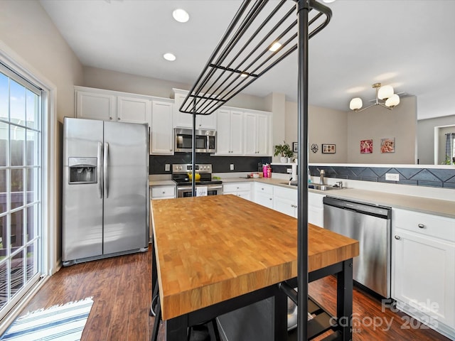 kitchen featuring decorative backsplash, sink, dark wood-type flooring, appliances with stainless steel finishes, and white cabinets