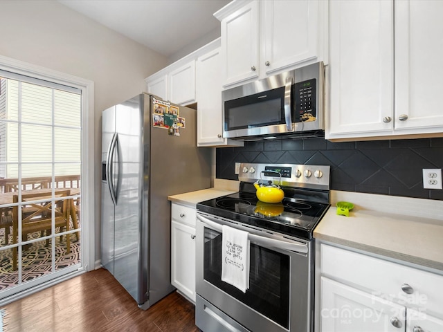 kitchen with backsplash, white cabinets, dark hardwood / wood-style flooring, and stainless steel appliances