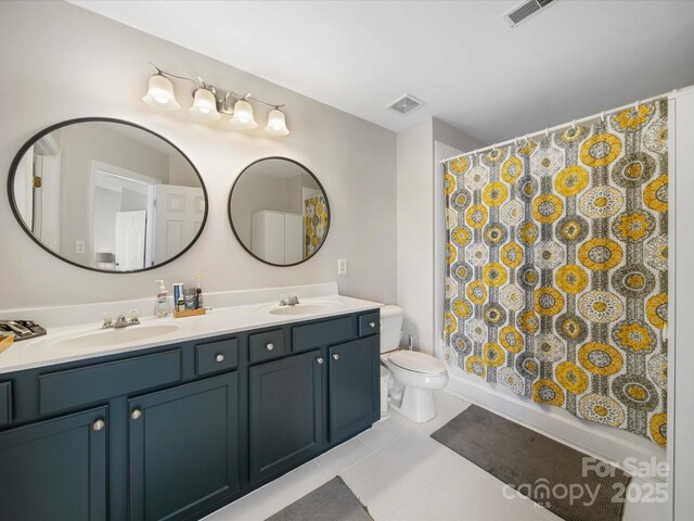 bathroom featuring curtained shower, tile patterned floors, vanity, and toilet