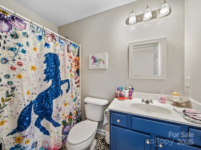 bathroom featuring toilet, vanity, and curtained shower