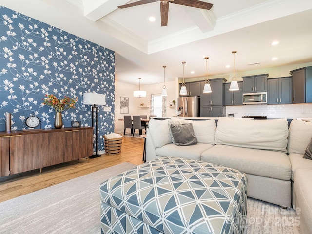 living room featuring ceiling fan, crown molding, light hardwood / wood-style flooring, and beam ceiling