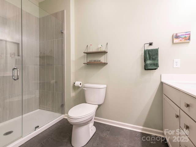 bathroom featuring toilet, a shower with shower door, and vanity