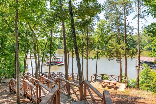 wooden deck with a water view and a boat dock