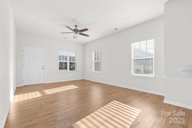 empty room with ceiling fan, light hardwood / wood-style floors, and plenty of natural light