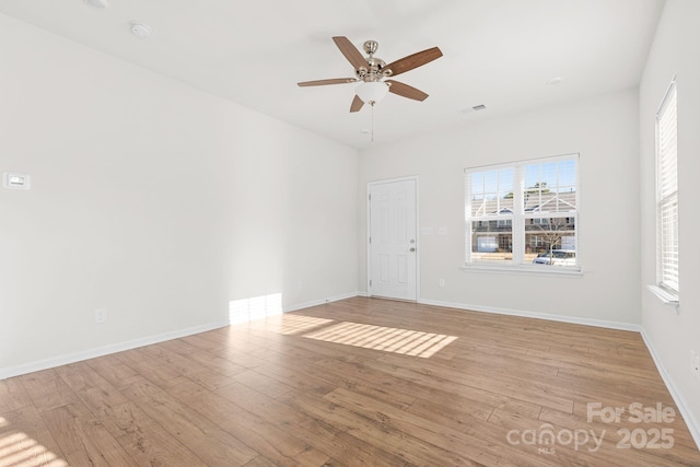 spare room featuring ceiling fan, light hardwood / wood-style flooring, and a healthy amount of sunlight