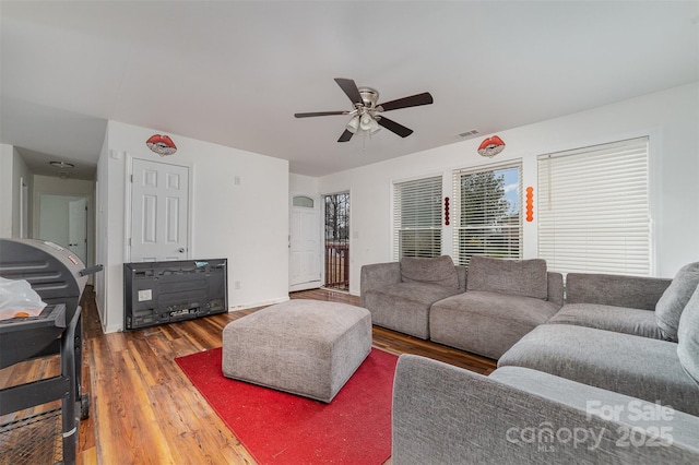 living room with dark hardwood / wood-style flooring and ceiling fan