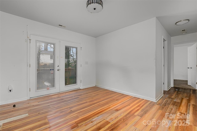 spare room featuring french doors and hardwood / wood-style floors