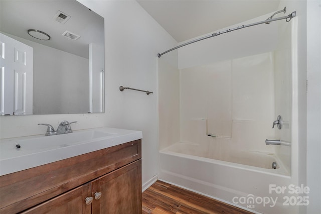 bathroom with vanity, wood-type flooring, and washtub / shower combination