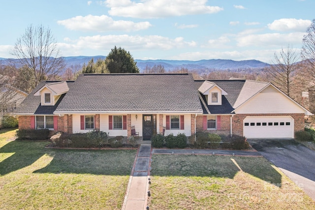 new england style home with a front lawn, a mountain view, and a garage