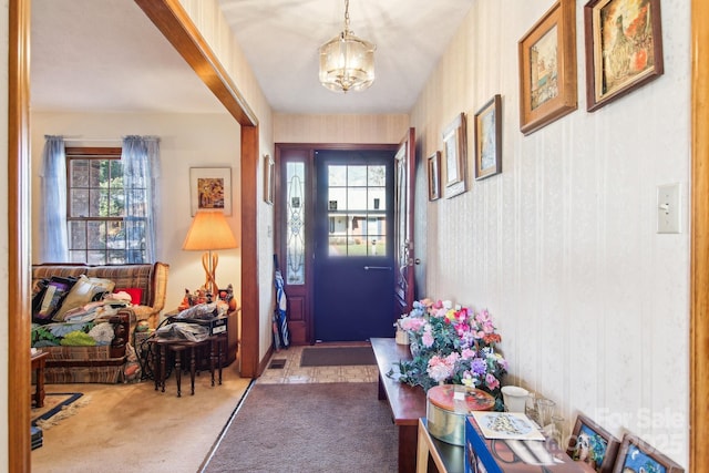 entryway featuring carpet floors and an inviting chandelier