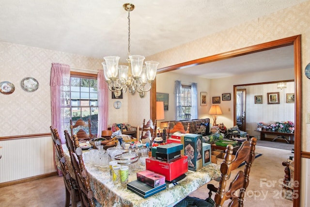 dining area featuring light carpet and a notable chandelier