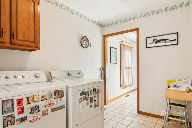 laundry room featuring washer and dryer, cabinets, and light tile patterned floors