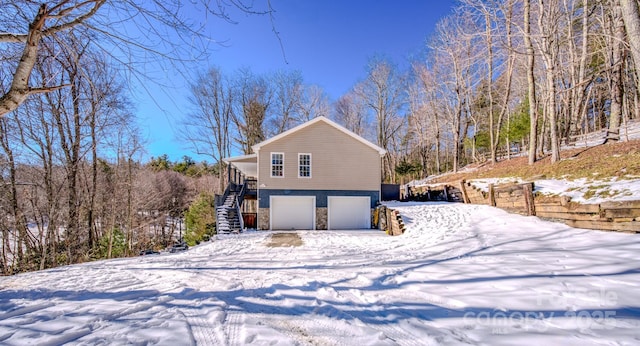 view of snowy exterior featuring a garage