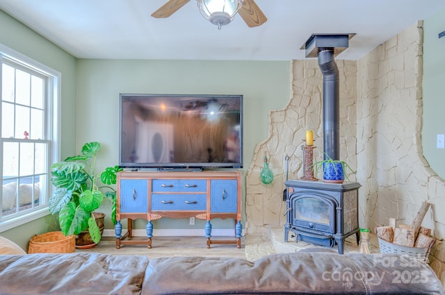 living room featuring ceiling fan and a wood stove