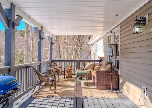 wooden deck with area for grilling and an outdoor living space