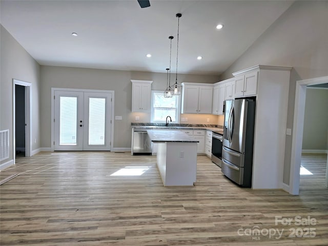 kitchen featuring pendant lighting, white cabinets, stainless steel appliances, and a kitchen island