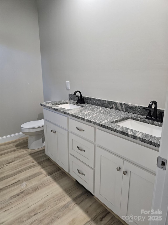 bathroom featuring toilet, hardwood / wood-style flooring, and vanity