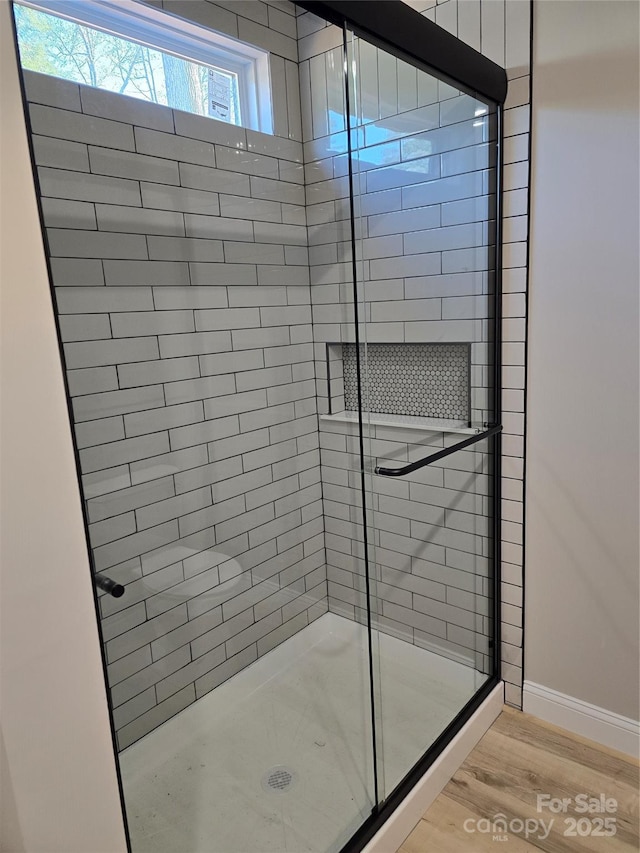 bathroom featuring wood-type flooring and an enclosed shower