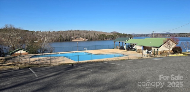 view of swimming pool with a water and mountain view and a patio