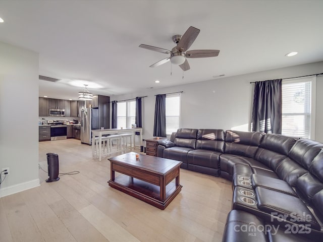 living room featuring ceiling fan, a healthy amount of sunlight, and light hardwood / wood-style flooring