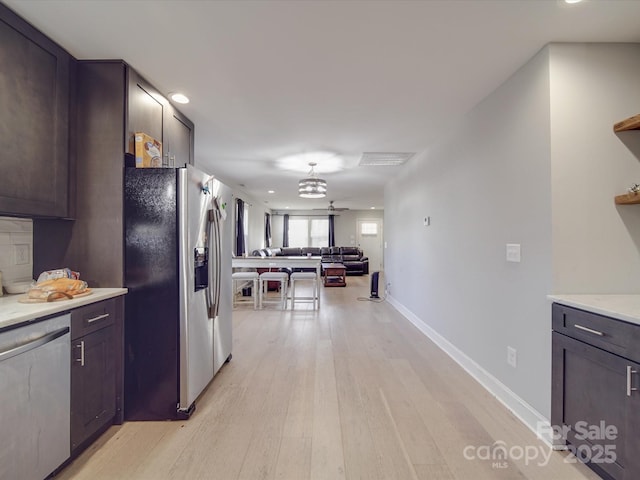 kitchen featuring dark brown cabinetry, appliances with stainless steel finishes, and light hardwood / wood-style floors